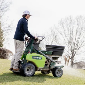 Matthews Turf Management employee using a Turfco turf care machine on a lawn