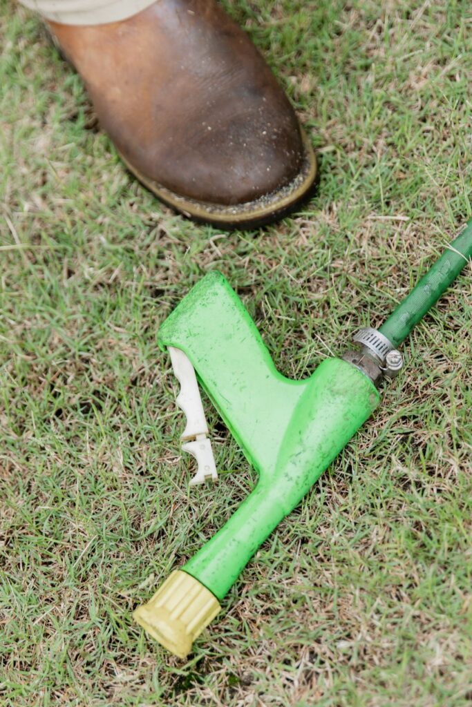 Weed control spray gun resting on treated turf
